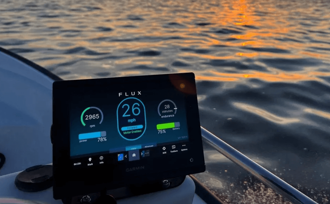 Flux Marine nav screen at the helm of a boat at sunset