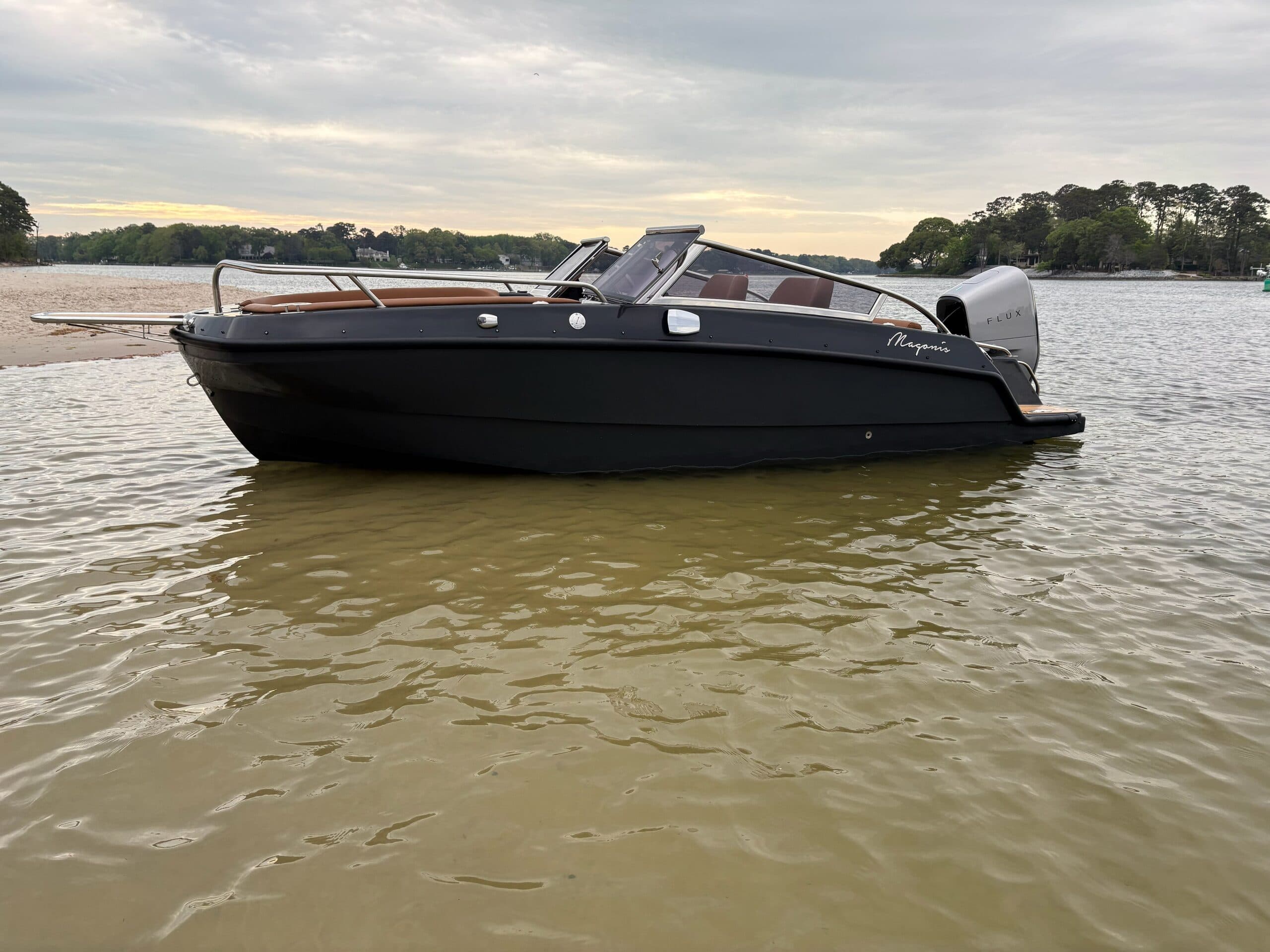 Charcoal grey Magonis e Wavee boat in low tide at sunrise full starboard side of the boat